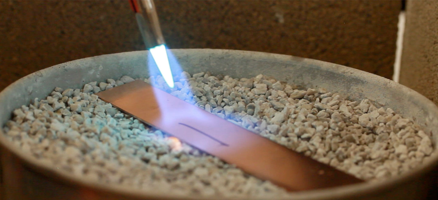 Jewelry soldering torch heating up a piece of copper sheet