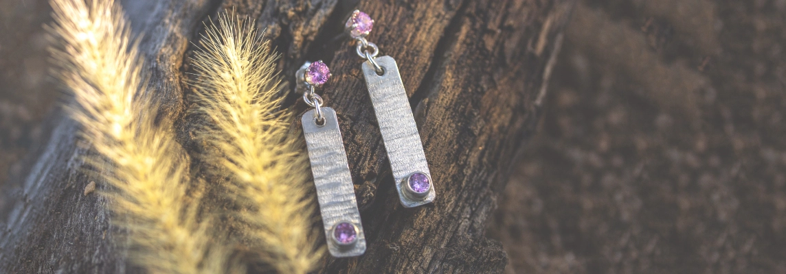 Pair of sterling silver dangle earrings with purple gemstones