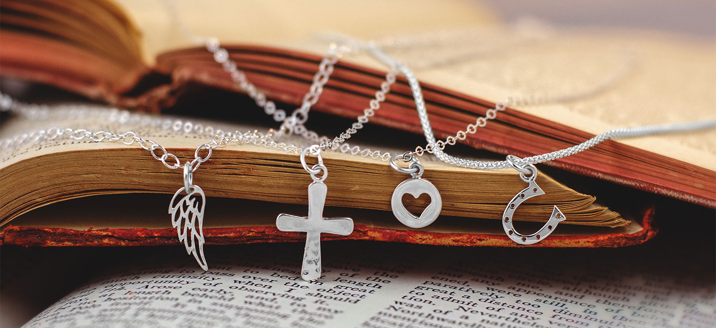 Sterling silver charm necklaces draped on a book