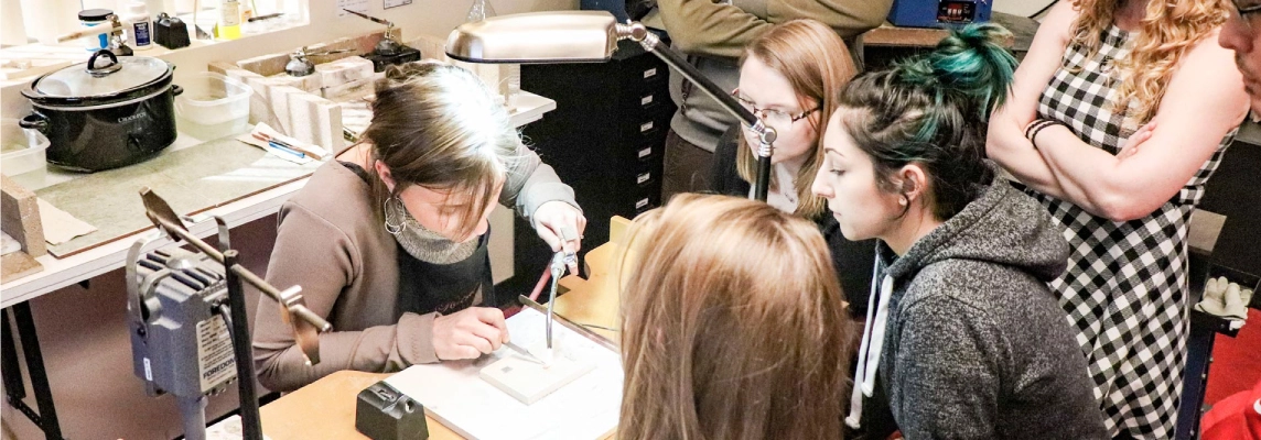 Halstead employees watching a jewelry artist demo