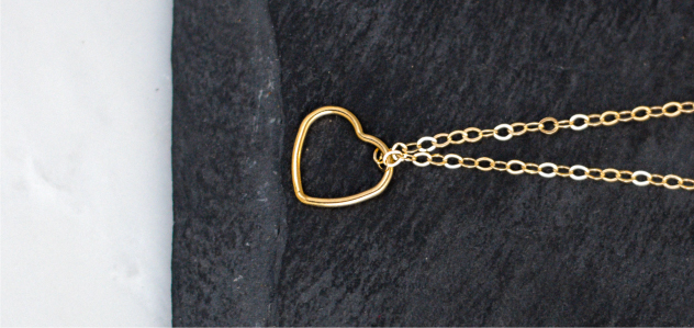 Gold-filled heart necklace on black tabletop