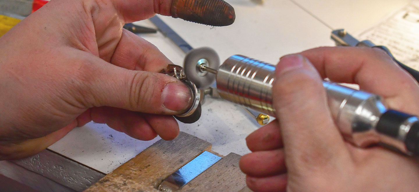 Jeweler's hands polishing a ring with a flex shaft