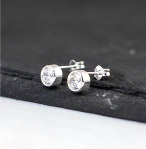 Pair of sterling silver and cz stud earrings on a piece of slate