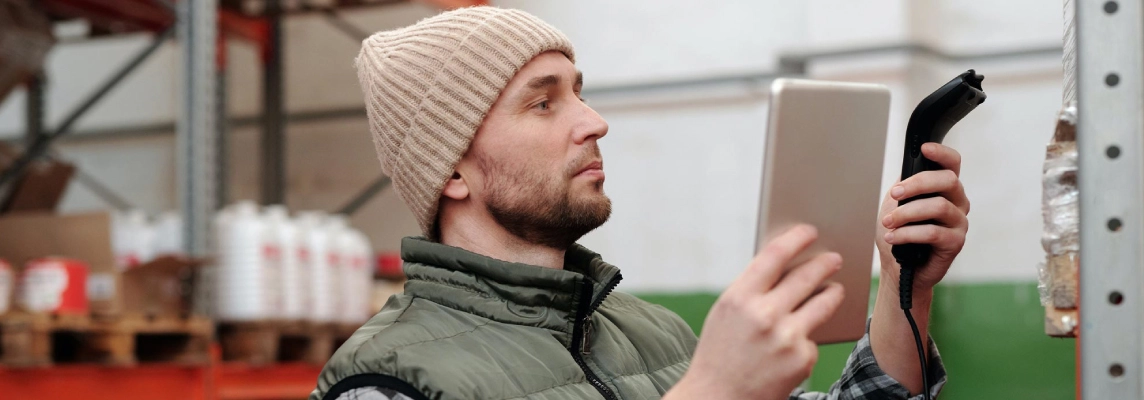 Man in warehouse scanning inventory on shelves