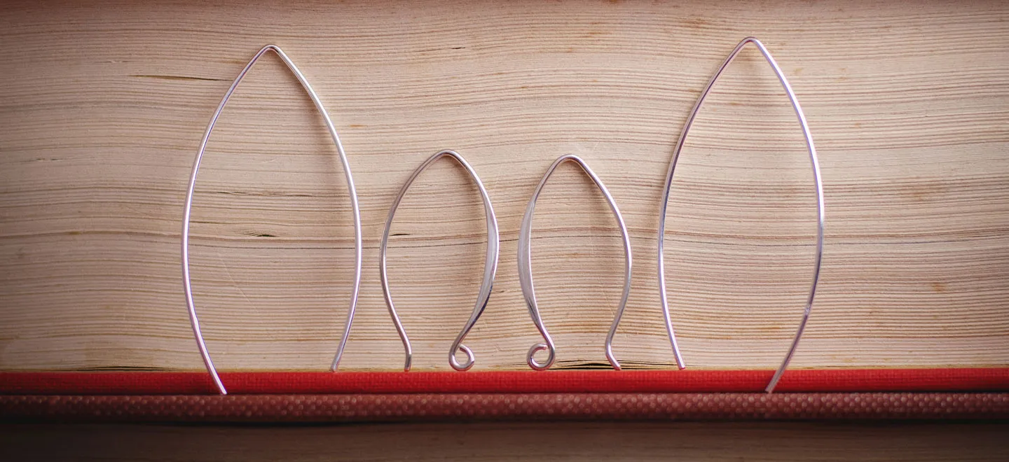 Sterling silver earwires lined up against a wall