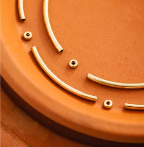 Gold jewelry beads and spaces laying on a terracotta pot