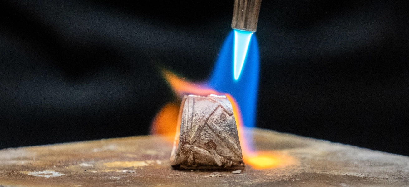 Tip of jewelry soldering torch flame on sterling silver ring in progress